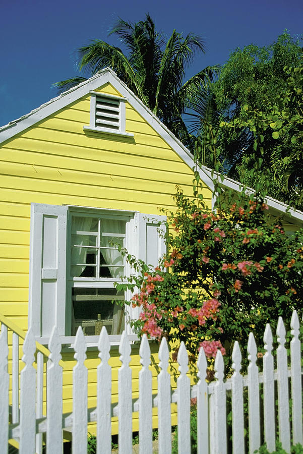Close-up of a Yellow house with white shutters and white picket fence, Dunmore Town, Harbor Island, Bahamas Photograph by Medioimages/Photodisc