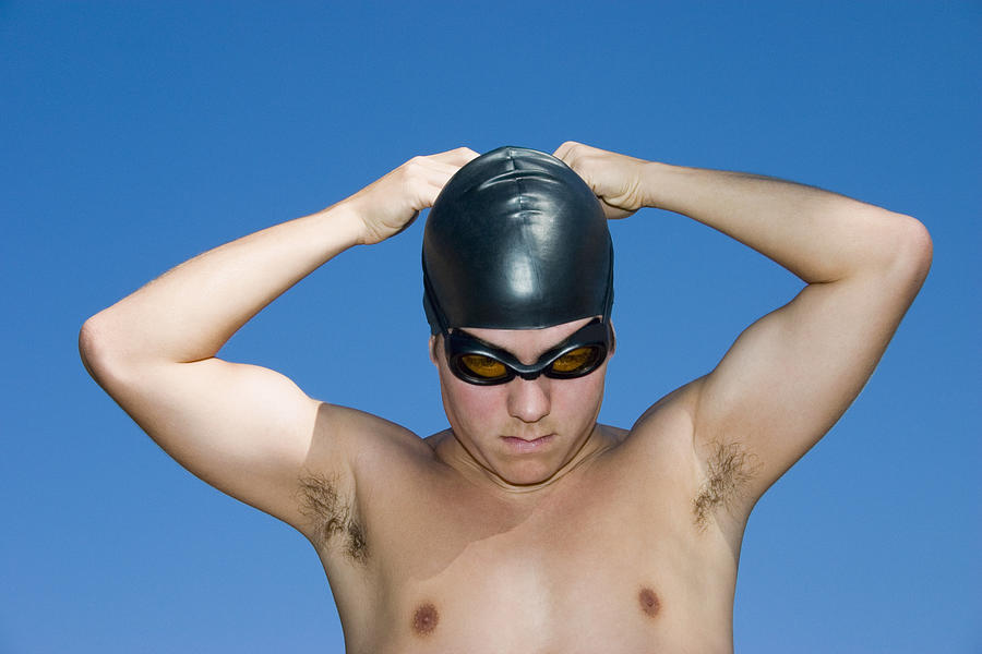 Close-up of a young man wearing a swimming cap Photograph by Glowimages