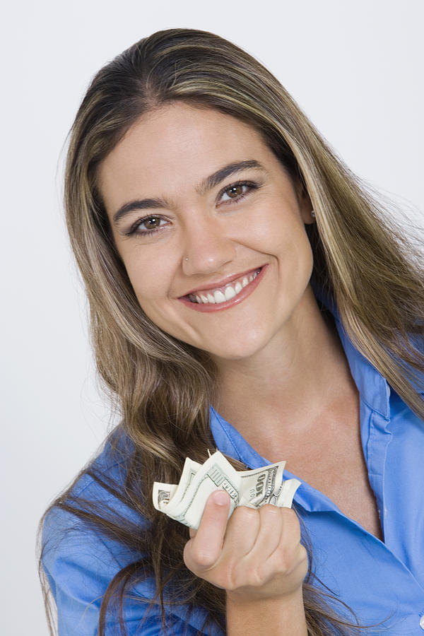 Close-up of a young woman holding US paper currency Photograph by Glowimages