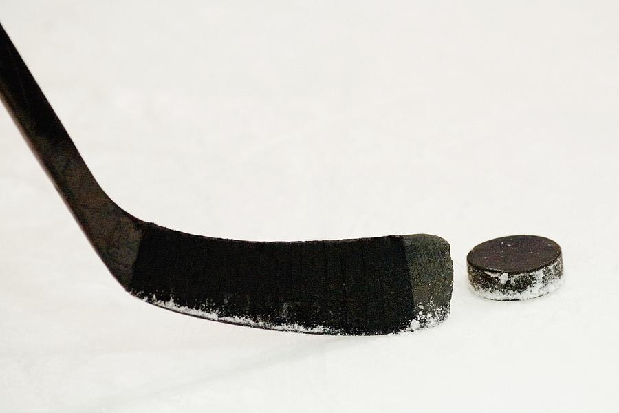 Close-up of an ice hockey stick with a hockey puck Photograph by Glowimages