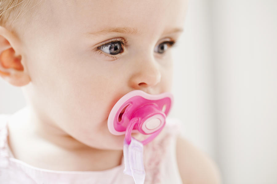Close up of baby with pink pacifier Photograph by Compassionate Eye Foundation/Three Images