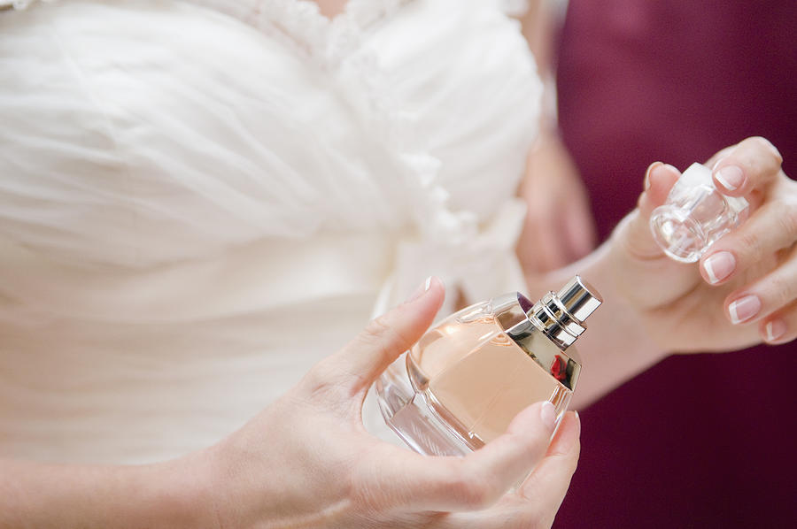 Close up of bride taking top off perfume bottle.  Photograph by RK Studio/Dean Sanderson