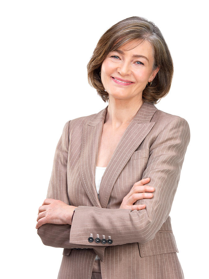 Close-up of businesswoman smiling with arms crossed against white background Photograph by Jacob Wackerhausen