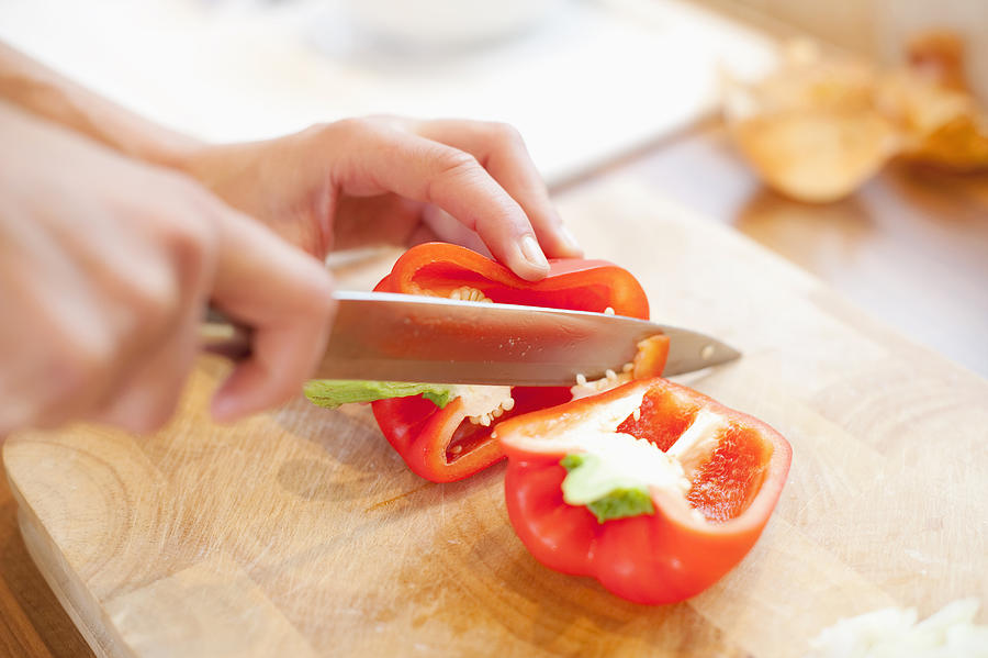 Close up of Caucasian woman slicing red bell pepper Photograph by Jacobs Stock Photography Ltd