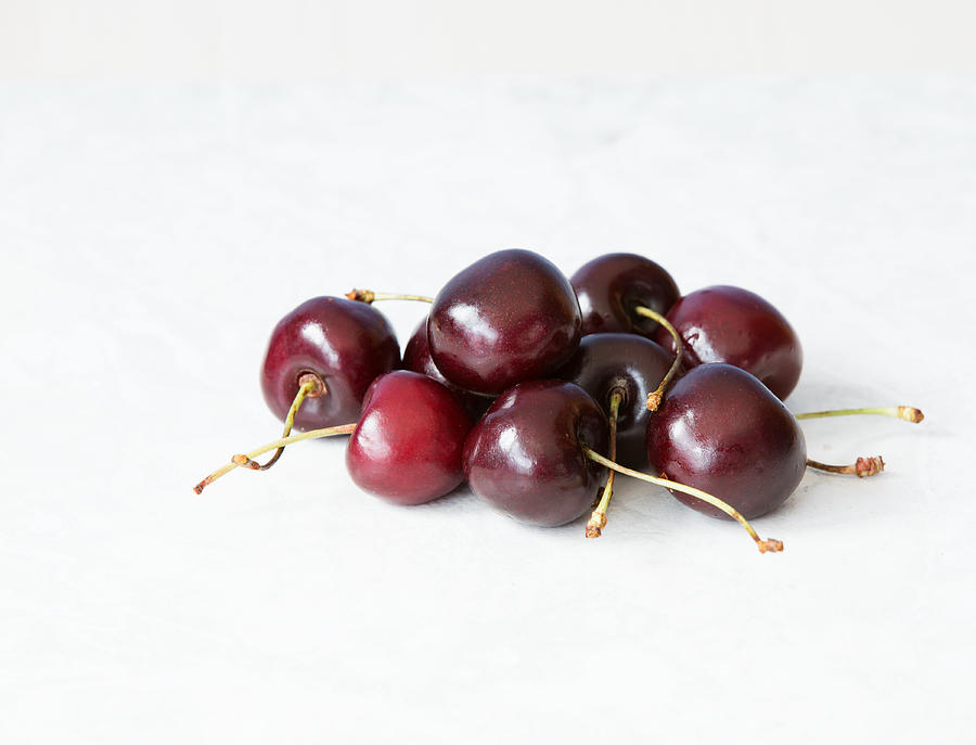 Close-up of cherries over white background Photograph by Jean-Marc PAYET
