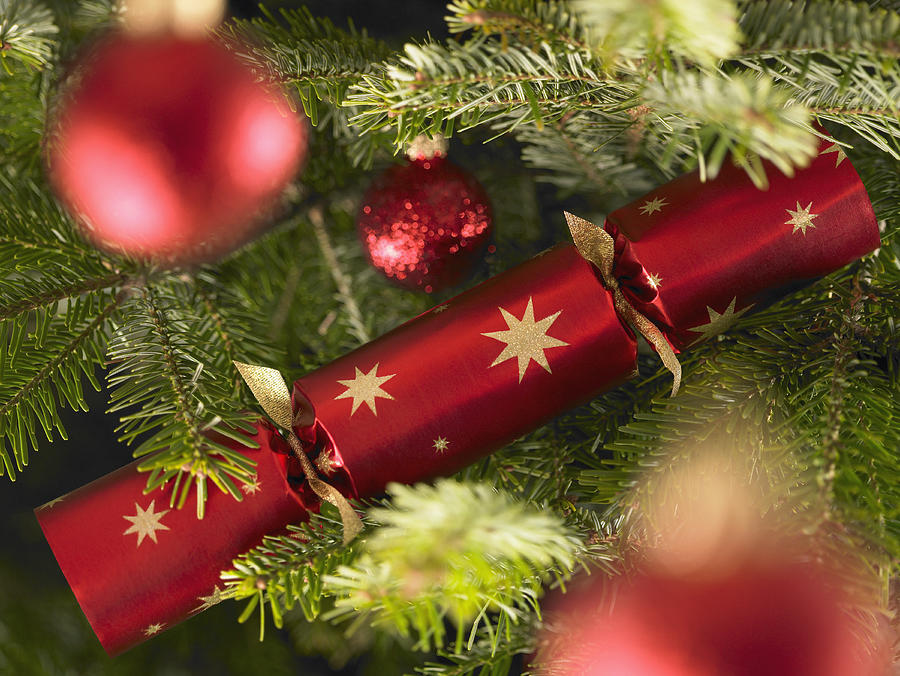 Close up of Christmas cracker and ornaments on tree Photograph by Adam Gault