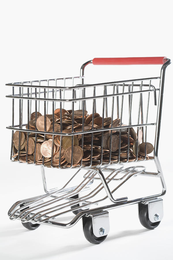 Close-up of coins in a shopping cart Photograph by Glow Images