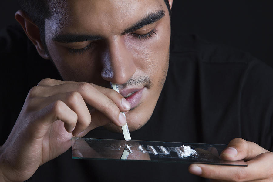 Close-up of drug addict snorting cocaine against black background Photograph by Sudipta Haldar
