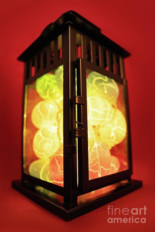 Close up of Easter egg shaped lights in a black lantern Photograph by Mendelex Photography