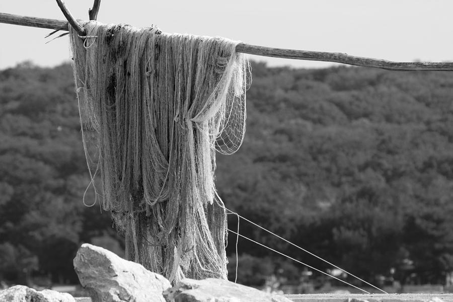 Close-up of fishing net on wood Photograph by Marek Michalek / FOAP