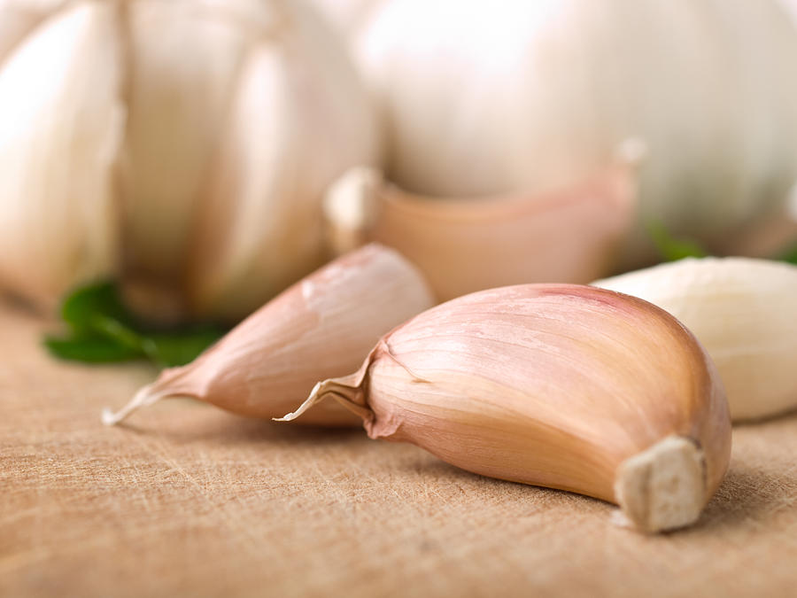 Close-up of garlic cloves laying on a table Photograph by Xxmmxx