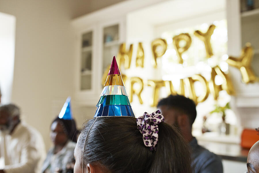 Close-up of girl wearing party hat at home Photograph by Klaus Vedfelt