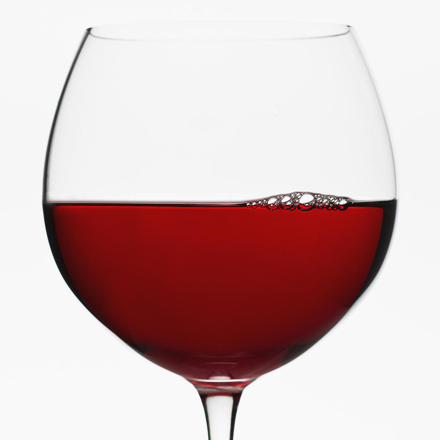 Close up of glass of red wine on white background Photograph by Tetra Images