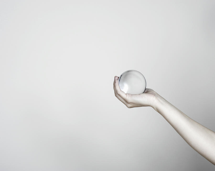 Close-up of hand holding a crystal ball Photograph by Flashpop