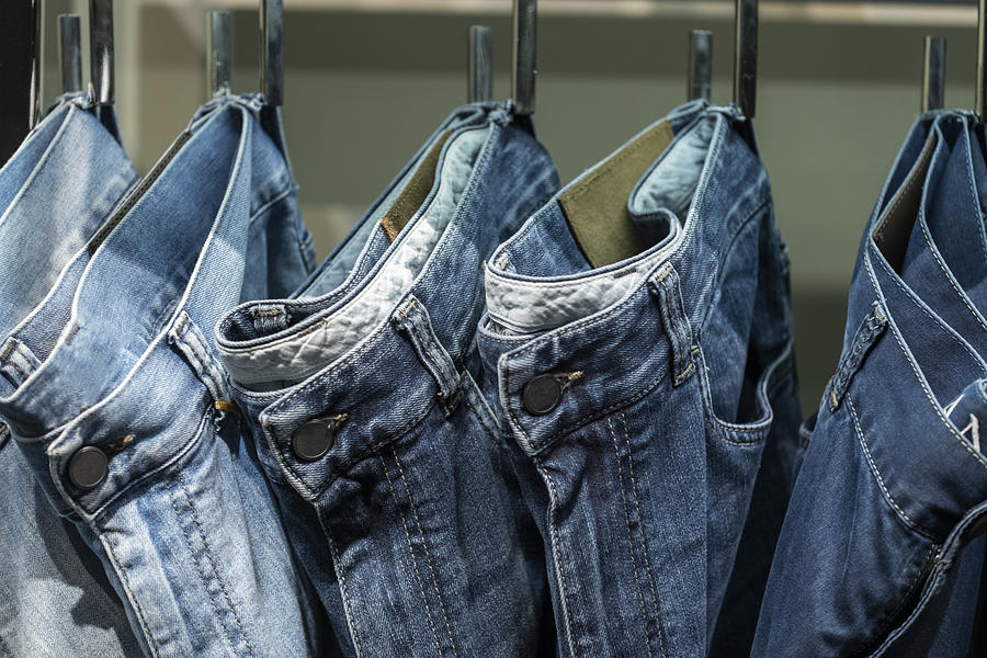 Close up of jeans hanging on clothe sack in a row Photograph by Fancy.yan