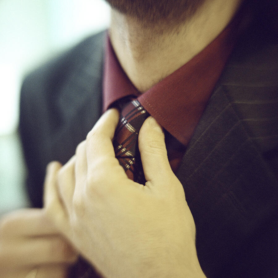Close-up of man fixing tie. Photograph by Patrick Sheandell OCarroll