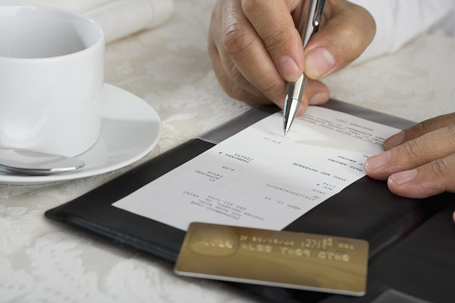 Close up of man signing credit card receipt at restaurant Photograph by Tetra Images