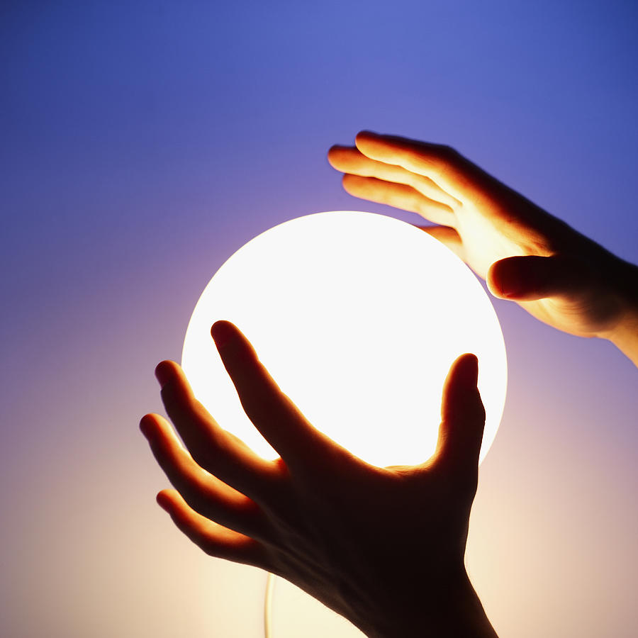 Close-up of mans hands touching crystal ball Photograph by Stockbyte
