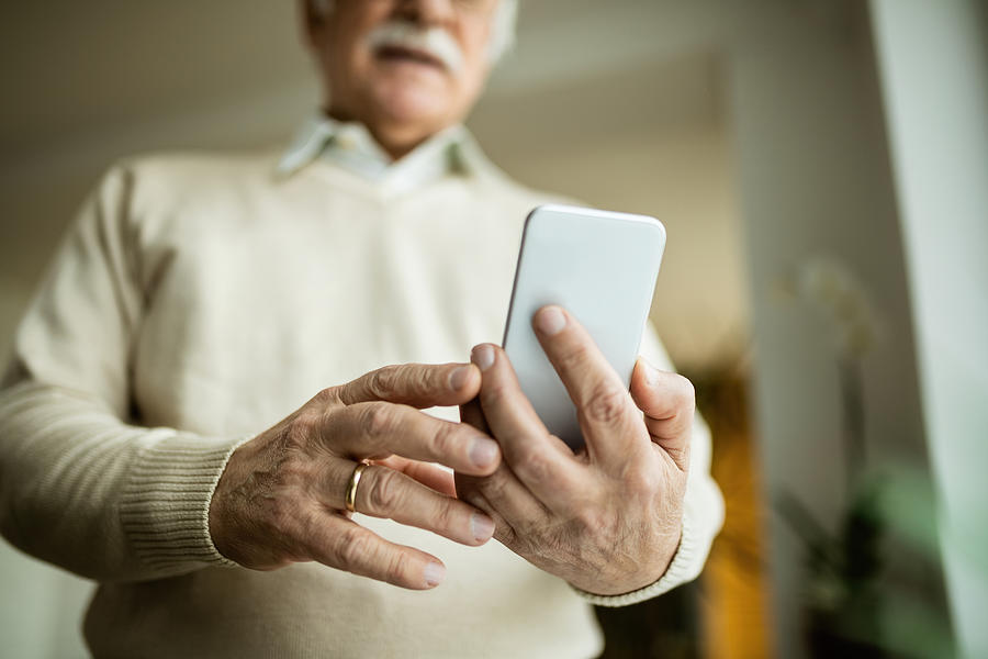 Close-up of mature man using smart phone. Photograph by Drazen Zigic