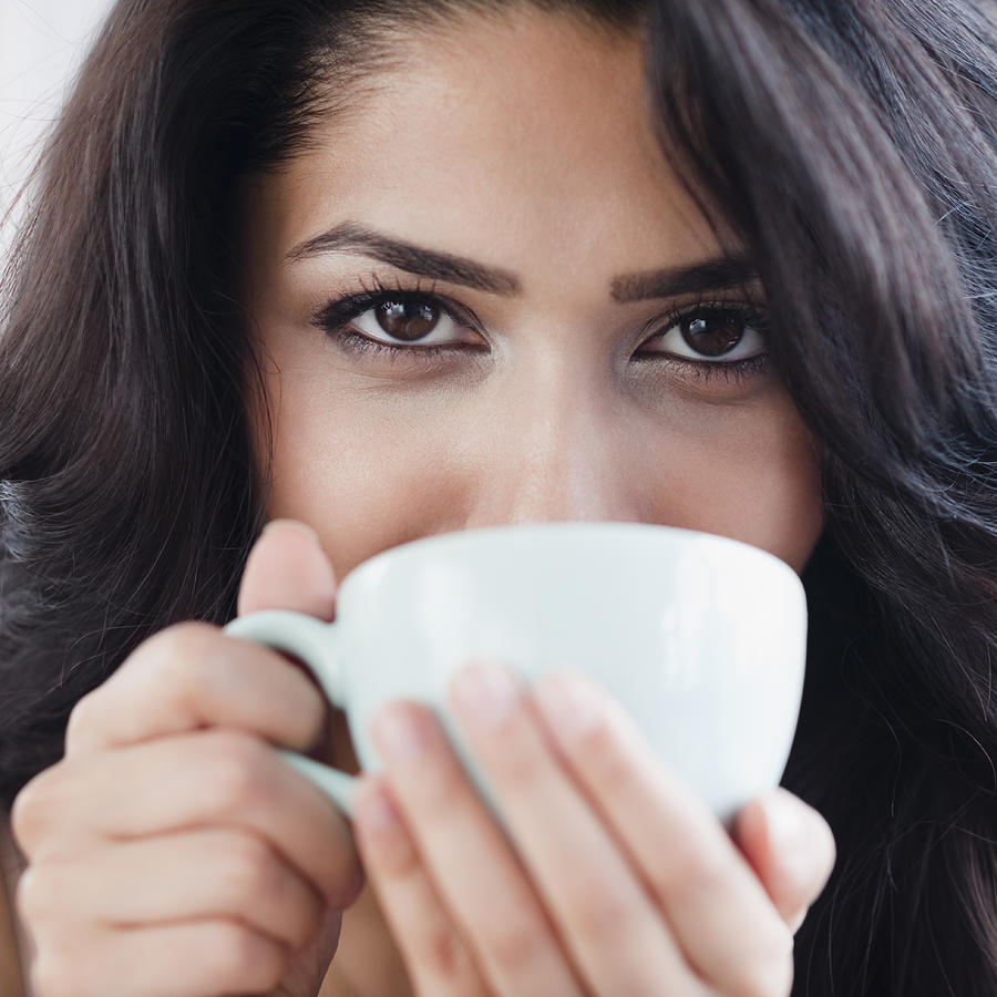 Close up of Middle Eastern woman drinking coffee Photograph by Blend Images - JGI/Jamie Grill