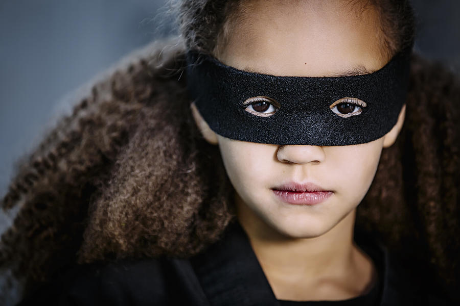 Close up of mixed race girl wearing mask Photograph by Inti St Clair