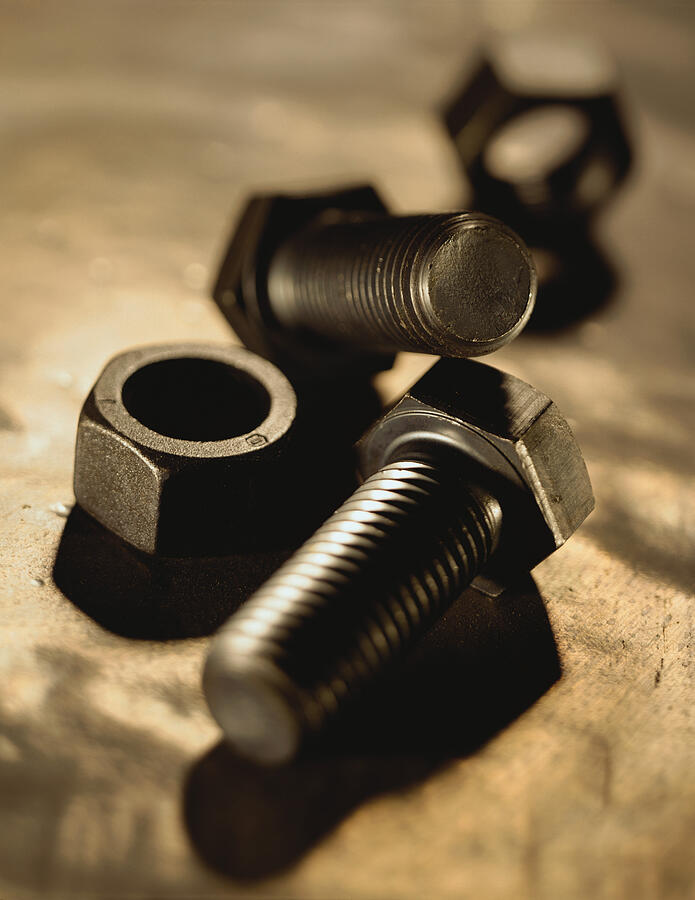 Close-up Of Nuts And Bolts Lying On A Gray Surface Photograph by Photodisc