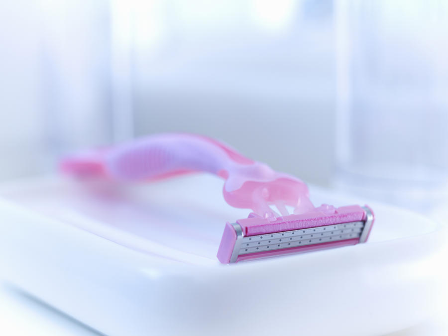 Close up of pink razor in bathroom Photograph by Adam Gault
