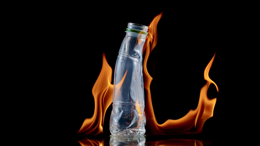 Close-up of plastic bottle melting by fire Photograph by Simonkr