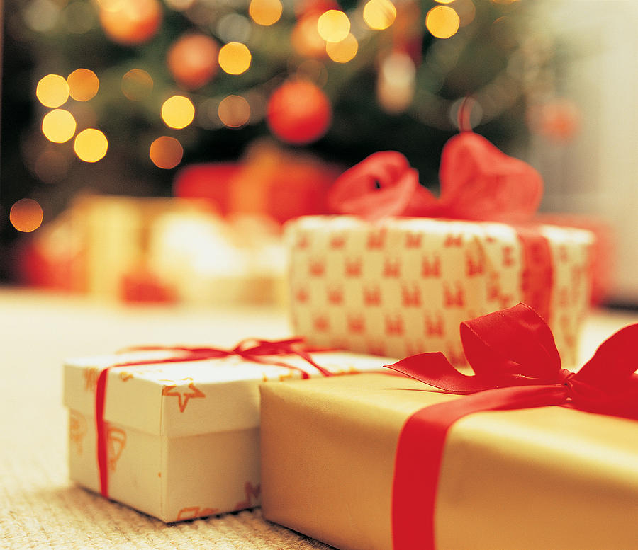 Close-Up of presents with Christmas Tree in background Photograph by Digital Vision.