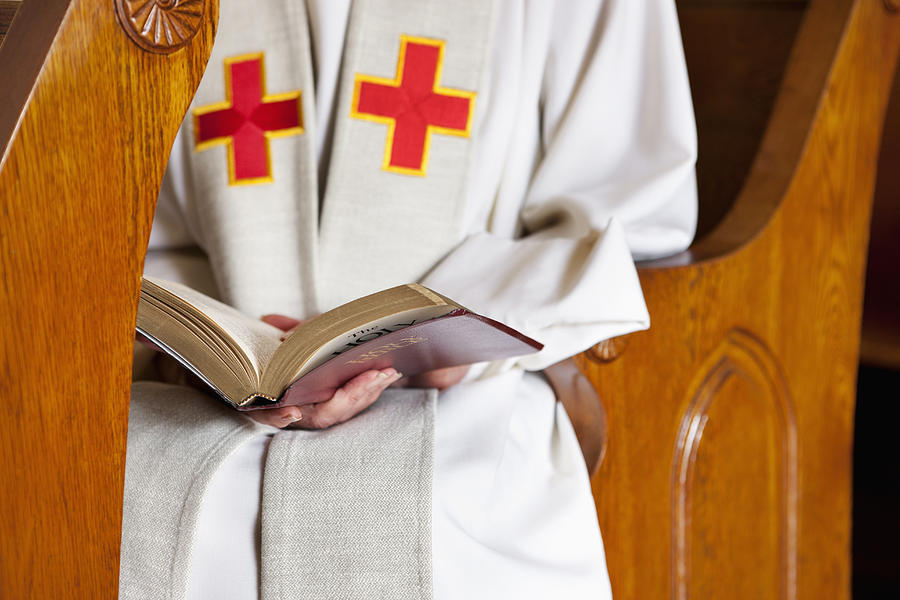 Close up of priest reading Bible Photograph by Robert Nicholas