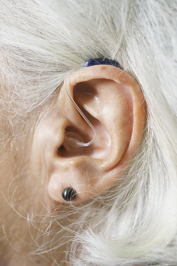 Close-up of senior womans ear wearing hearing aid Photograph by Halfdark