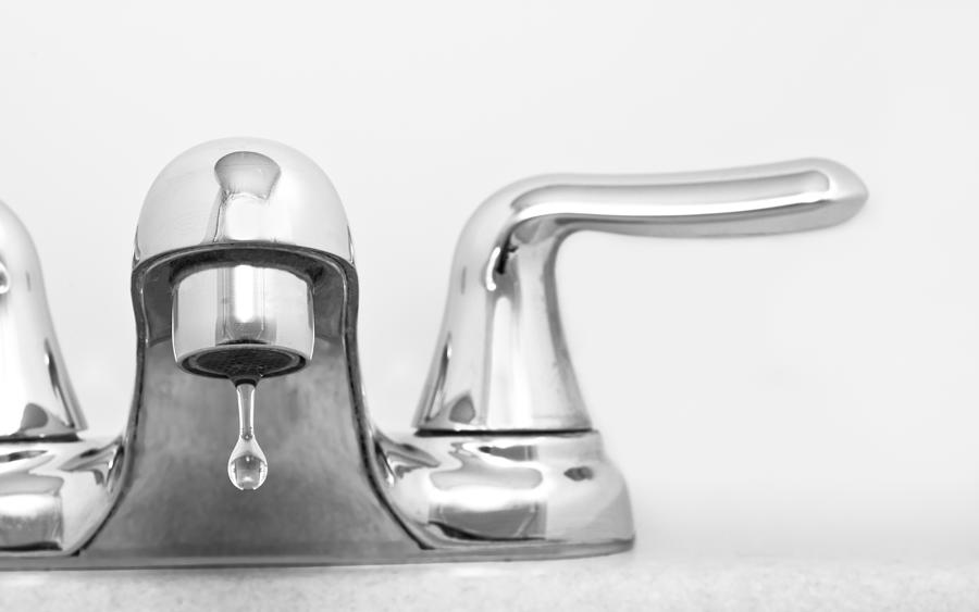 Close up of stainless steel faucet dripping water Photograph by Edelmar