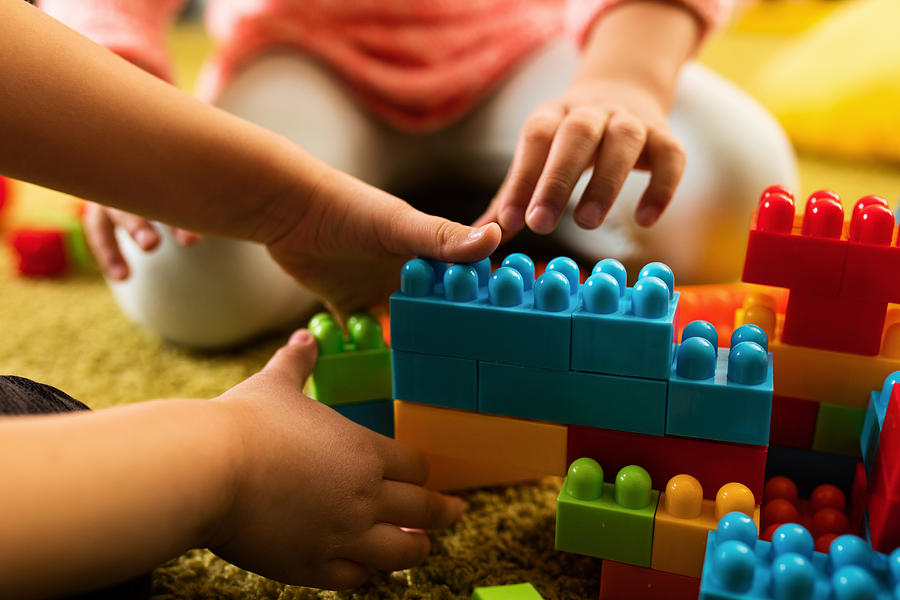 Close-up of two children playing with toy blocks. Photograph by Skynesher