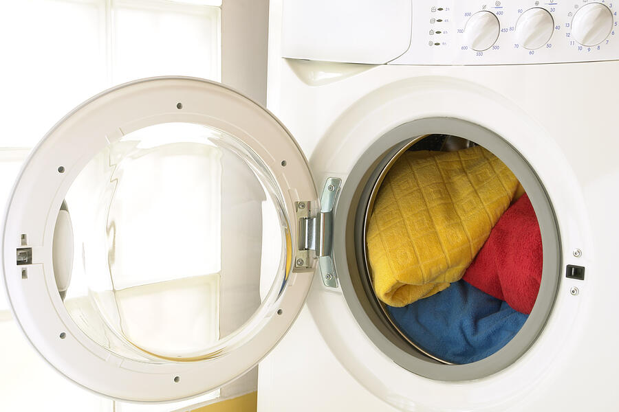 Close-up of washing machine, opened door, laundry inside, three towels Photograph by Domin_domin