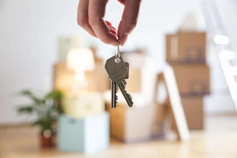 Close-up of woman holding house key in new home Photograph by Westend61