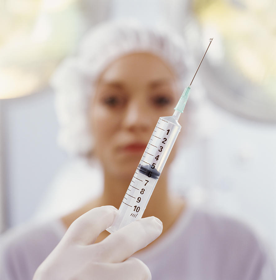Close-Up on a Syringe in the Foreground, Patient in the Background Photograph by Andrew Olney