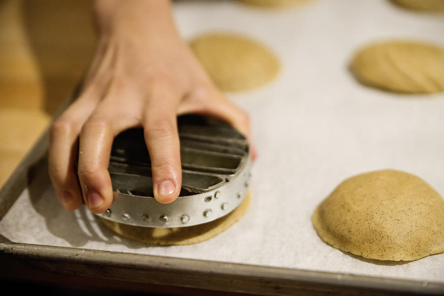 Close-up on womans hand making conchas. Photograph by Martinedoucet