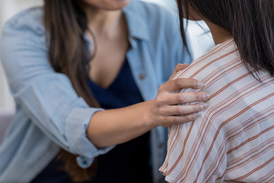 Close up photo of moms comforting hand on daughters shoulder Photograph by SDI Productions
