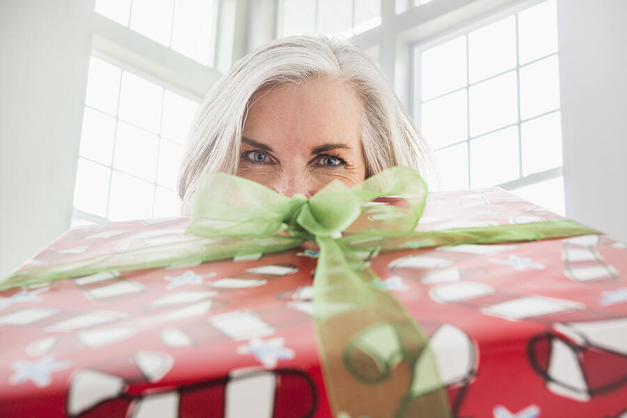 Close up portrait of Caucasian woman with Christmas gift Photograph by Mike Kemp