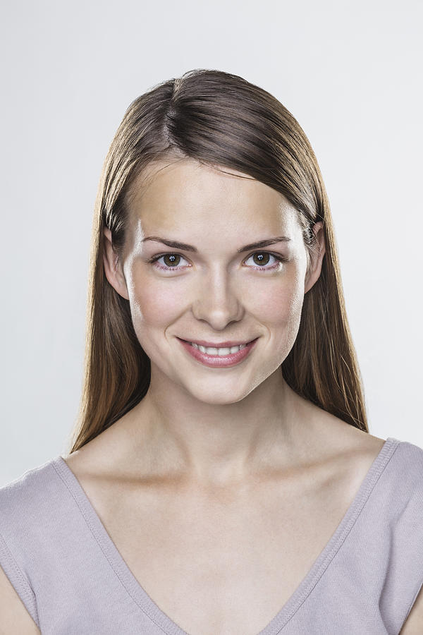 Close-up portrait of smiling young woman against white background Photograph by Vladimir Godnik