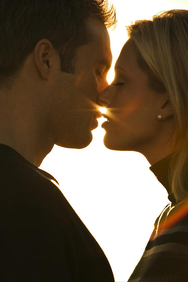 Close Up Shot As A Young Adult Couple Lean In To Kiss Each Other Photograph by Photodisc