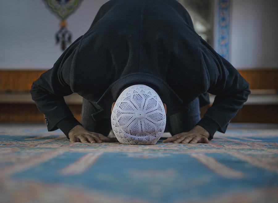Close-up shot of a Muslim young man worshiping in a mosque Photograph by CiydemImages