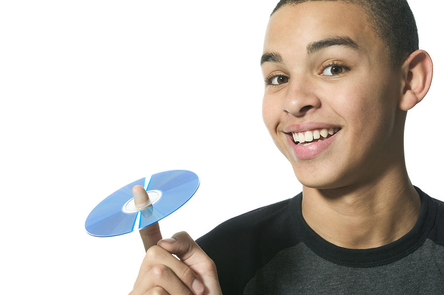Close Up Shot Of A Teenage Male As He Holds Up A Cd On His Finger Photograph by Photodisc