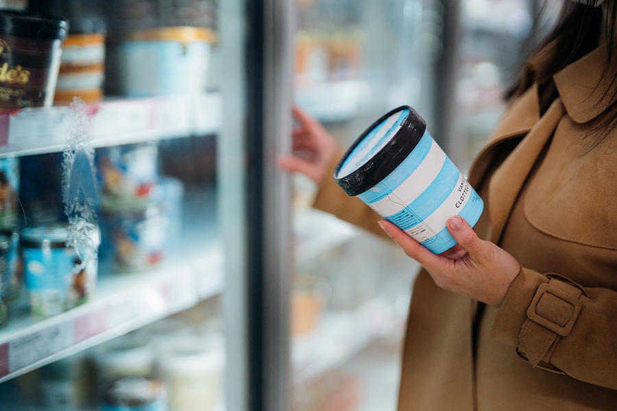 Close up shot of woman holding a cup of vanilla flavour ice cream in supermarket. Photograph by Oscar Wong