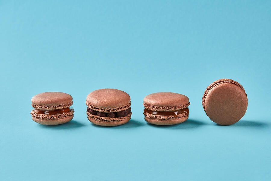 Close-up studio shot of tasty chocolate macarons on blue background Photograph by Sergey Nazarov