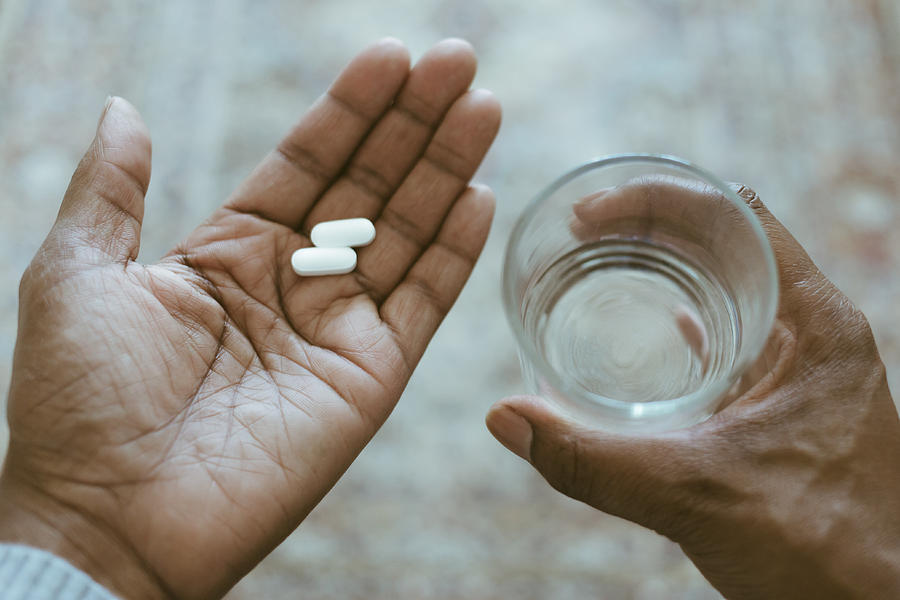 Close-Up View of Hands Holding Pills and Water Photograph by Grace Cary