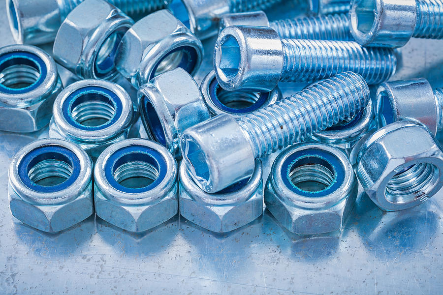 Close up view of threaded construction nuts and screw bolts Photograph by Mihalec