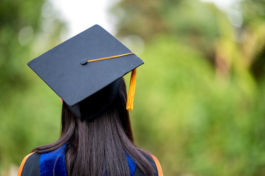 closeup behind a female college graduate wearing a black fringe gown and a black hat, Concept of Successful Education in Hight School,Congratulated Degree Photograph by Nirat