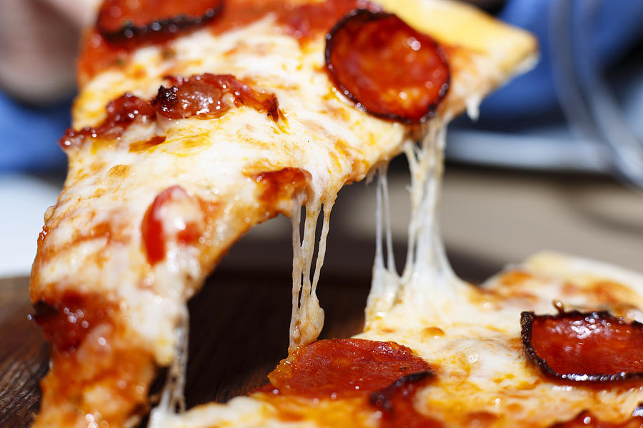 Closeup of a piece of pepperoni pizza. Italian pizza. Photograph by Gannamartysheva