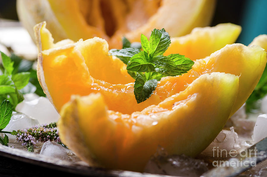 Closeup Of Cantaloupe Melon Slices With Mint And Ice Served  On Photograph
